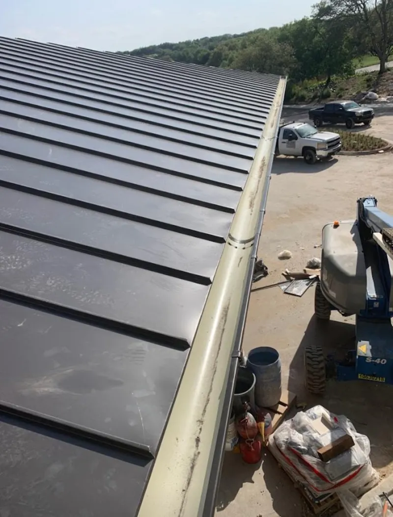 Standing seam panel and gutter detail on a metal roofing jobsite in Burlington